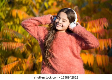 feeling inspired with favorite song. little child in headset. enjoy autumn day. good day for park walk. she love nature and music. feel real joy. fall mood melody. small girl listen audio book.