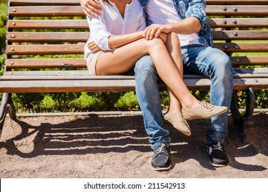 Feeling safe near him. Close-up of loving couple bonding to each other while sitting on the bench 