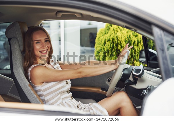 Feels good. Female driver inside of modern\
automobile. Testing brand new\
car.
