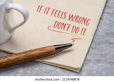 if it feels wrong do not do it advice, handwriting on a napkin with a cup of coffee, instinct and gut feeling concept