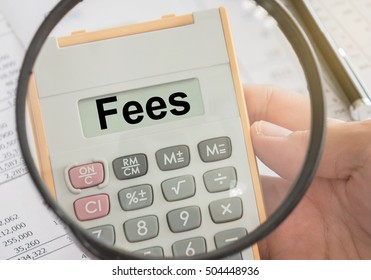 fees text displayed on calculator and magnifier. bank fees, service fee concept.