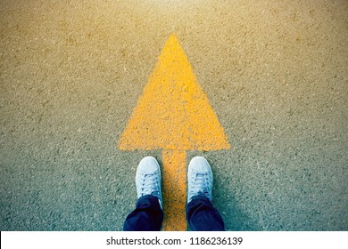 Feet and arrows on road. - Shutterstock ID 1186236139
