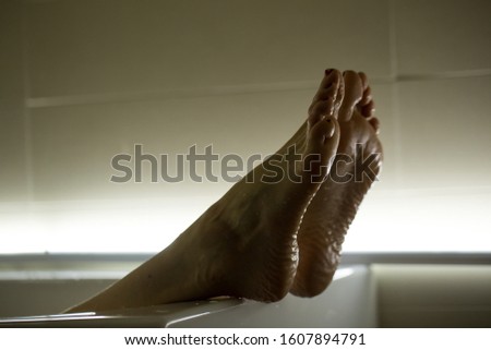 Feet in the bathroom closeup. Steamed female heels. Manicure.