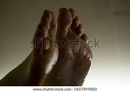 Feet in the bathroom closeup. Steamed female heels. Manicure.