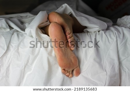 Feet in bed out of sheets