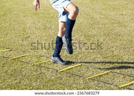 The feet of a boy doing ladder training.