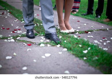 Feet Of Bride In Classic Shoes On Wedding Towel, Sprinkled Petals Of Roses