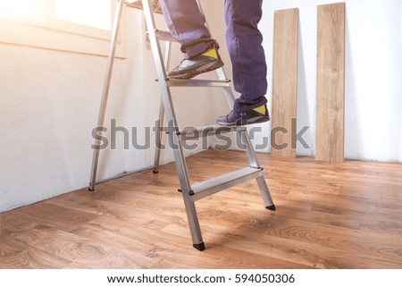 Feet of a carpenter  ready for work on a ladder