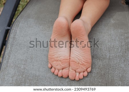 Feet of a child with flowers on green grass