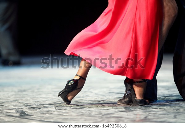 Feet closeup of Argentinian tango dancer in a red\
dress. Argentina tango.