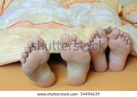 Feet of a couple in bed