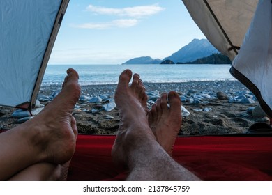 Feet of couple tourists laying in the tent on the beach on Lycian Way. Beydaglari Coastal National Park, Antalya Province, Turkey.
