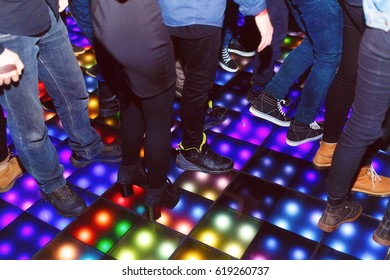 The Feet Of The Dancers On The LED Dance Floor