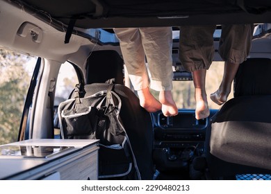 feet dangling off the elevated bed of a camper van