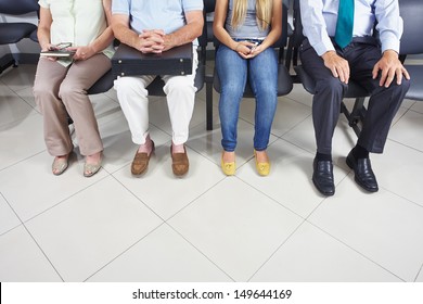 Feet of different people sitting in a waiting room