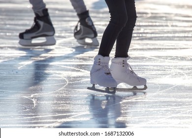 Feet Of Different People Skating On The Ice Rink