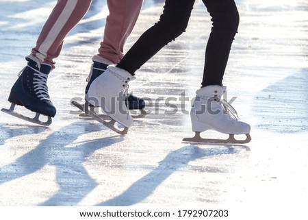 feet of different people skating on the ice rink. hobbies and leisure. winter sports
