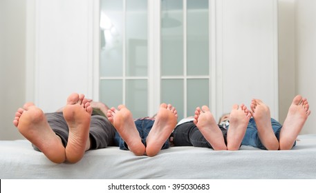 Feet Of A Family In Bed 

