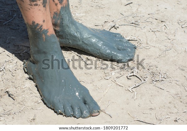 Feet of female feet in healing mud. Cosmetology\
and balneology for human\
health.