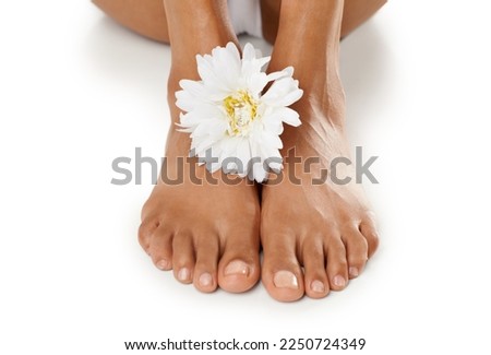 Feet, flower and natural skincare for pedicure, spa or relaxation against a white studio background. Isolated barefoot of toes with white floral petals for healthy treatment, body care or skin care
