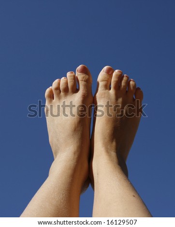 Feet of girl against the background at dawn sky
