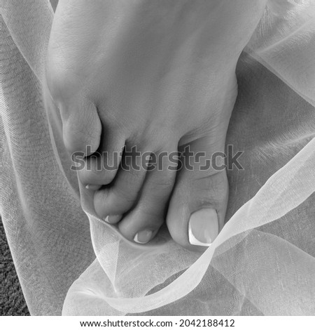 Feet of girl with manicure pedicure nail. Body care concept. Monochrome