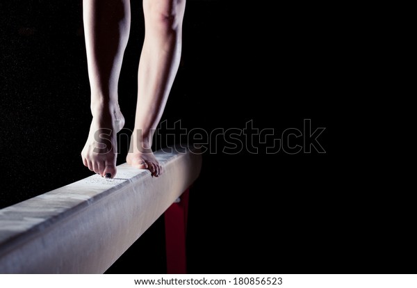 feet of gymnast on balance\
beam  