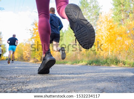 Feet of a jogger. Woman runs in the forest. Close-up of sneakers. Helathy lifestyle.