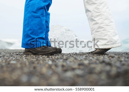 feet of kissing couple on black beach in Iceland