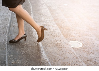 Feet And Leg Of Businesswoman Wearing Black High Heel Shoes Going Up The Stairs Outdoors. Young Woman Go To Work At Office.