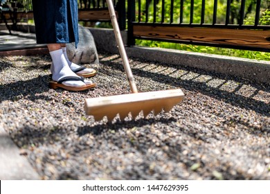 Feet Of Man In Kimono Costume And Geta Tabi Shoes Socks In Outdoor Garden Raking Rock Garden In Japan