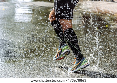 feet men athletic compression socks running in spray of water during sports  race