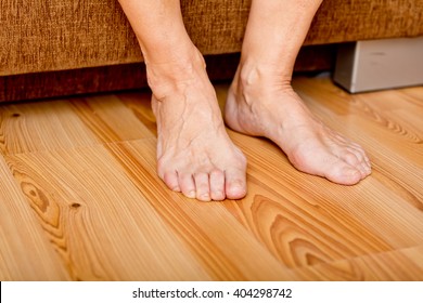 Feet Of Old Woman On The Floor