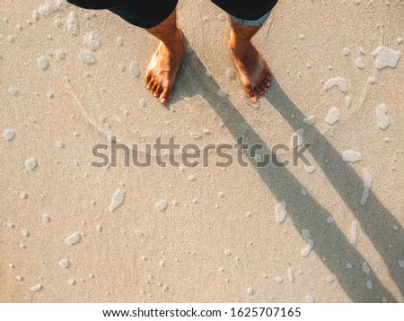 The feet on the beach floor by the sea. Lifestyle healthy