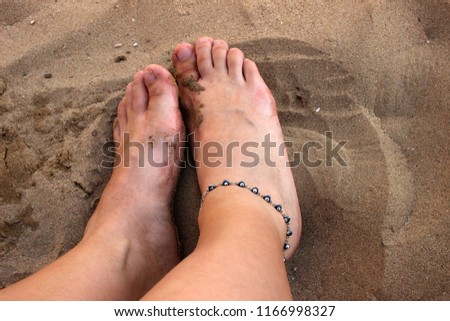 feet on the beach sand
