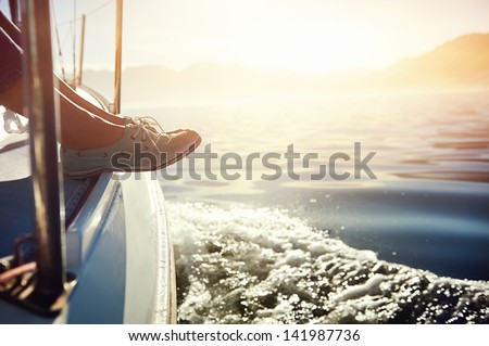 feet on boat sailing at sunrise lifestyle