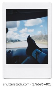 Feet on dashboard of car on highway