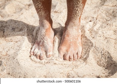 feet on the sand of a beach