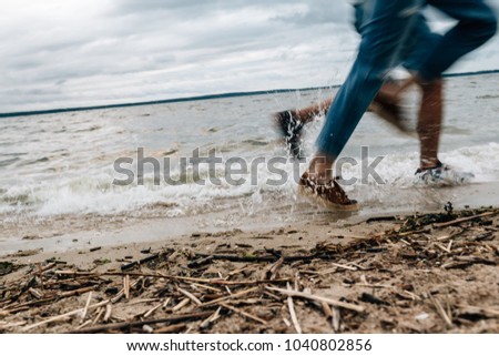 feet on the sand near the water