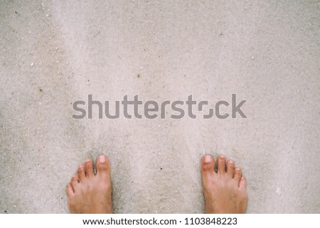 Feet on sand and wave at beach, Vacation holiday summer concept at ocean and beach.