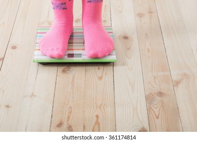 Feet on scales on wooden floor