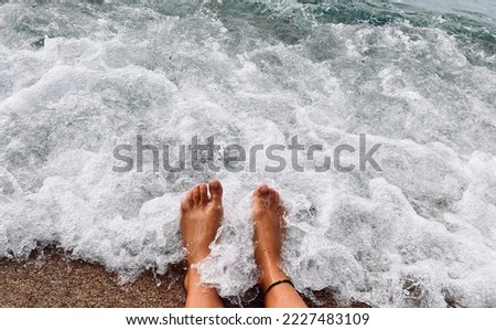 Feet on the seashore. Summer background with space for text.
