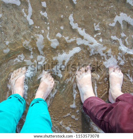 Feet on the wet sand on the beach. Nature background