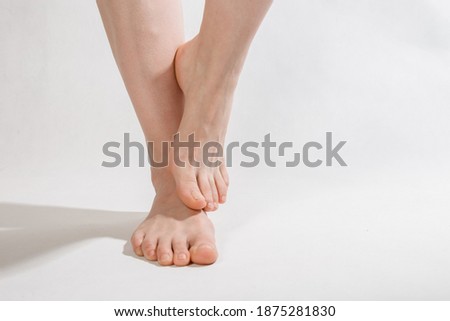 feet on a white background one foot lifted