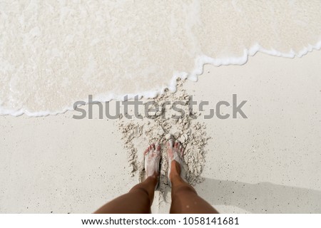 Feet on a white sand beach