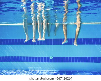 Feet Of People Moving Under The Water In The Pool