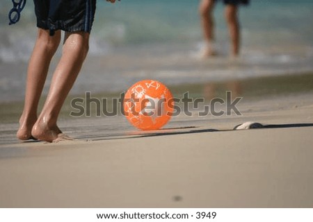 feet playing ball on a sandy beach