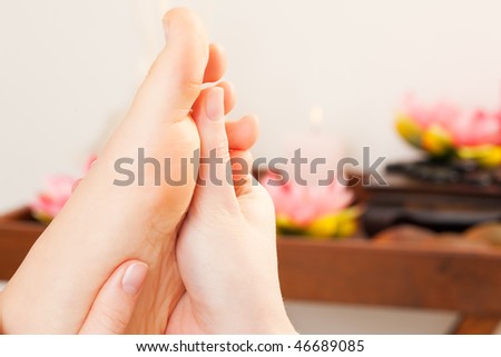 Feet receiving a massage in a spa setting (close up on feet)