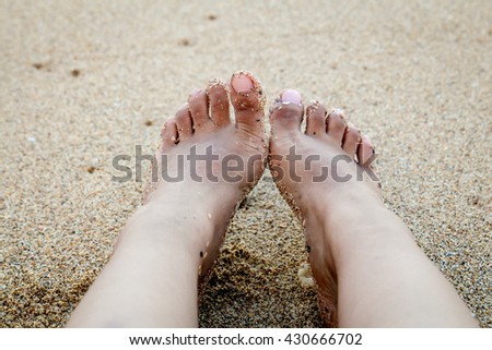 Feet relax on the beach 