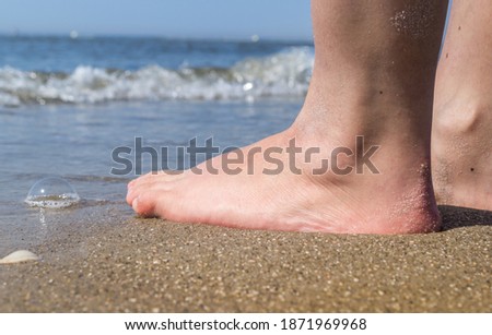 Feet relaxing by the sea in the sand